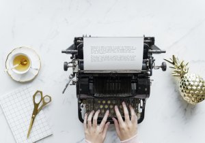 Aerial view of woman typing on a retro typewriter