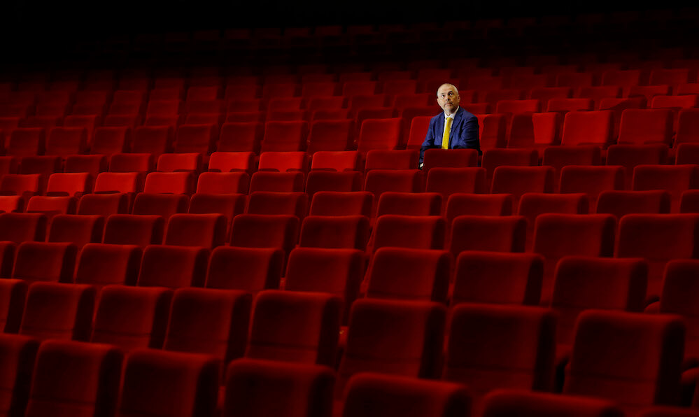 A staff member sits inside an empty cinema before a broadcast of an opening ceremony, as the Karlovy Vary International Film Festival launches a nationwide programme to bring its films to cinemas around the country after cancelling its main events following the coronavirus disease (COVID-19) outbreak in Karlovy Vary, Czech Republic, July 3, 2020.  REUTERS/David W Cerny