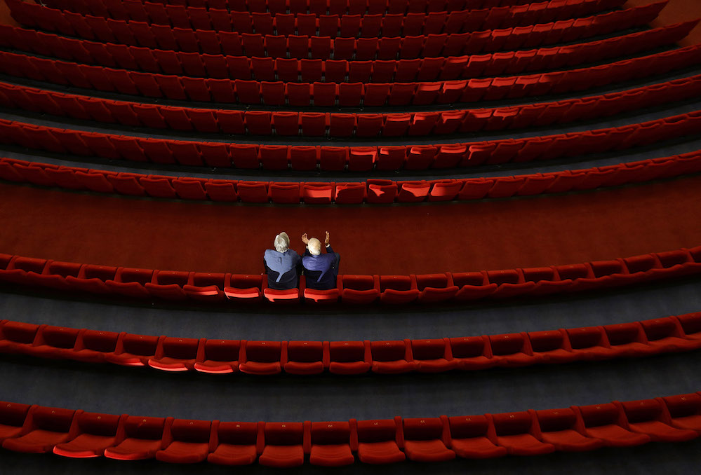 Festival President Jiri Bartoska and a staff member sit inside an empty cinema before a broadcast of an opening ceremony, as the Karlovy Vary International Film Festival launches a nationwide programme to bring its films to cinemas around the country after cancelling its main events following the coronavirus disease (COVID-19) outbreak in Karlovy Vary, Czech Republic, July 3, 2020.  REUTERS/David W Cerny
