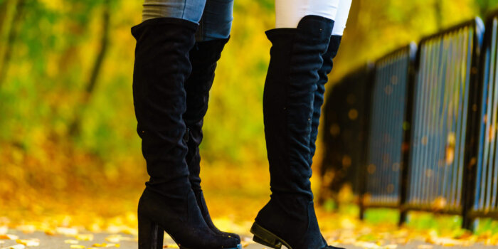 Two Unrecognizable Women Wearing Long Black Heeled Knee High Boots And Jeans. Autumn Fashion, Warm Footwear Boots.