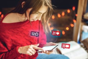 Woman Using Her Phone Spends Time On Social Looking At The Display And Reading The Comments To The Post On Christmas